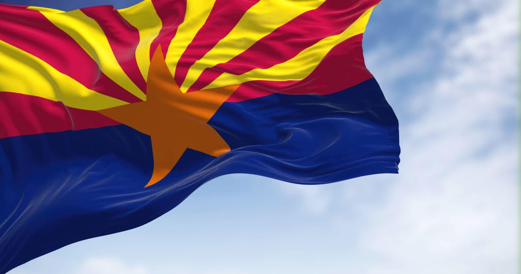 The state flag of Arizona waving in the wind on a clear day