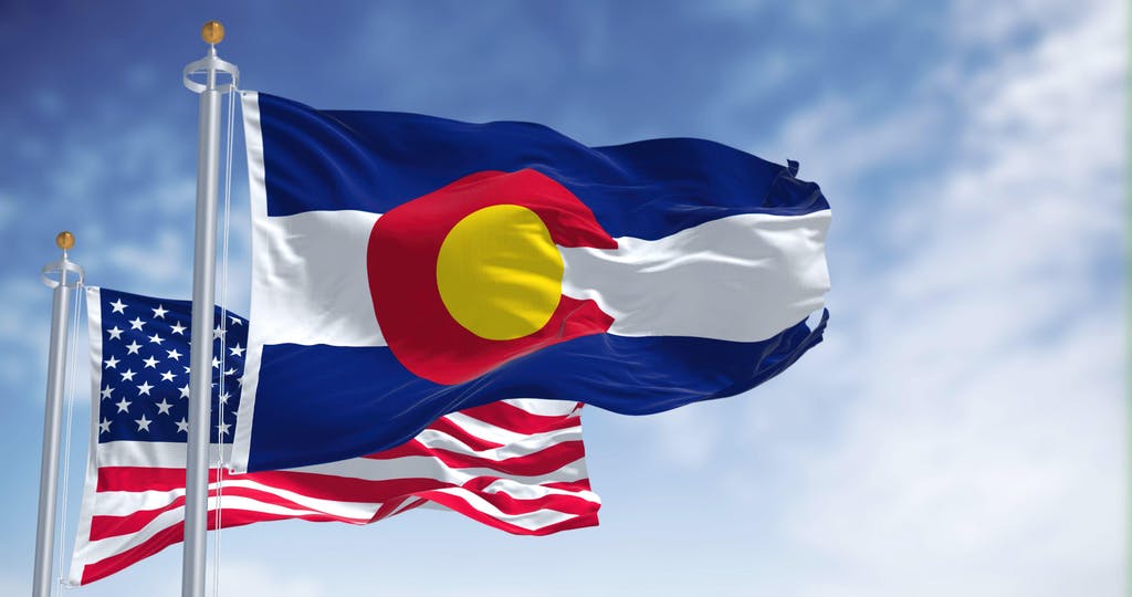 The Colorado state flag waving along with the national flag of the United States of America