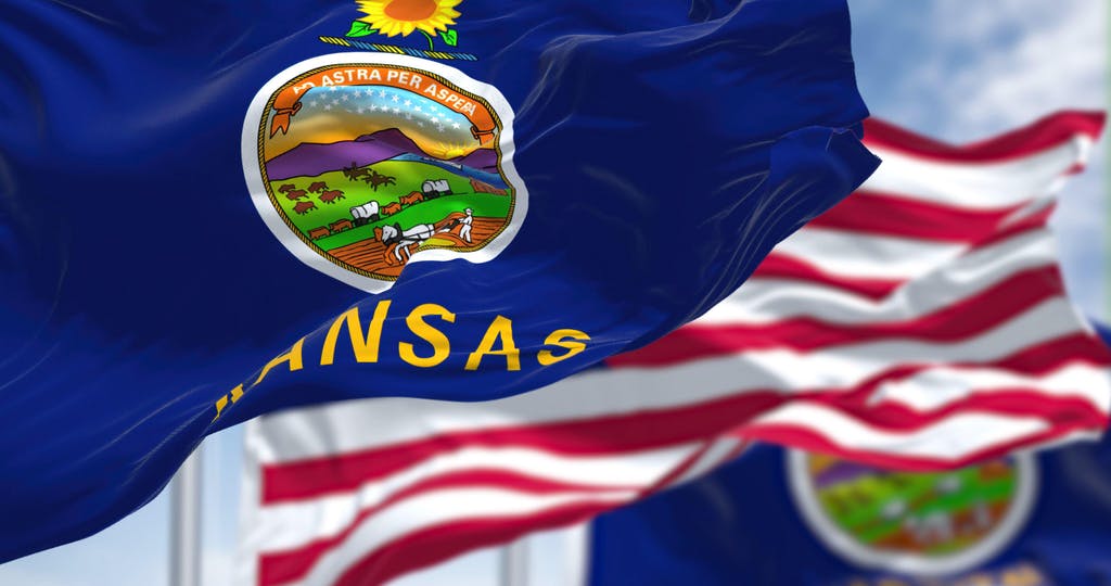 The Kansas state flag waving along with the national flag of the United States of America
